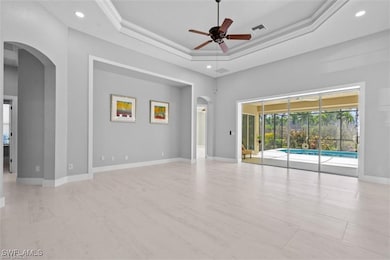 Spare room with visible vents, a tray ceiling, arc