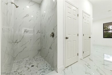 Bathroom with a marble finish shower and marble fi