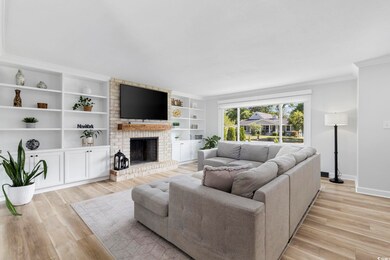 Living room with crown molding, a fireplace, baseb