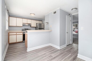 Kitchen featuring appliances with stainless steel finishes, extractor fan, light wood-type flooring, light countertops, and a peninsula