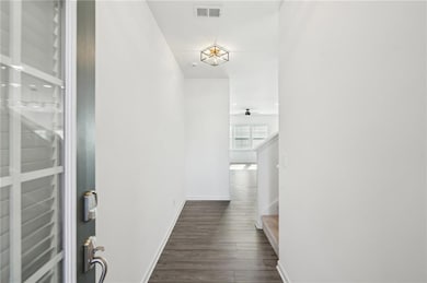 Corridor with baseboards, dark wood-style flooring