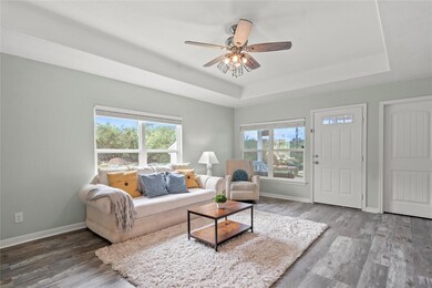 Living area featuring a raised ceiling, wood fini