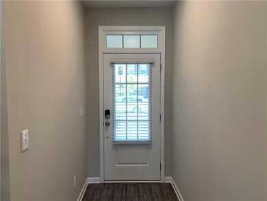 Doorway with healthy amount of natural light and dark wood-type flooring