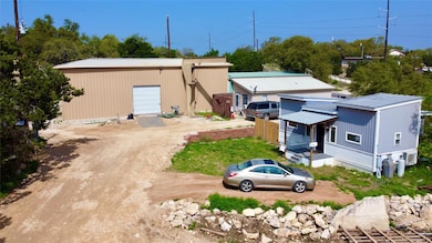 Back of property featuring metal roof, a garage, 