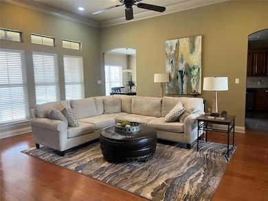 Living room featuring crown molding, ceiling fan, 