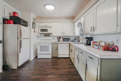 Kitchen with a textured ceiling, dark hardwood / w
