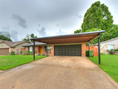 View of front of property with brick siding, a carport, and concrete driveway