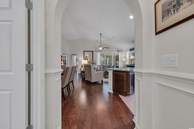 Entrance foyer featuring arched walkways, a ceiling fan, dark wood finished floors, and vaulted ceiling
