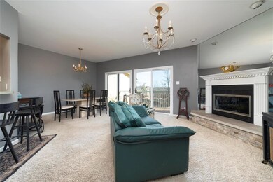 Open, bright gathering place features a woodburning fireplace with raised hearth and beautiful mantle.