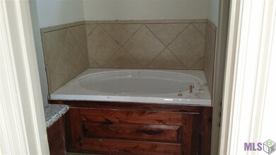 Soaking tub with ceramic tile backsplash. Master b