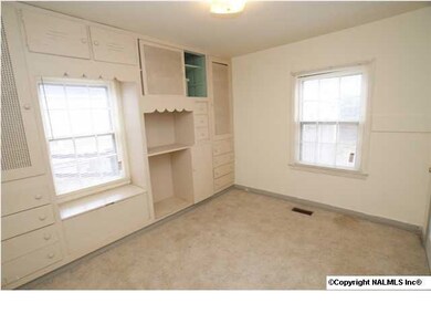 The guest bedroom has built-ins and a window seat