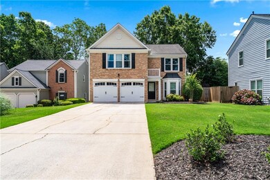 Traditional-style house featuring brick siding, concrete driveway, and a garage