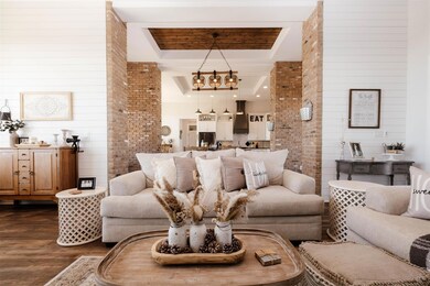 Living area with brick wall, a tray ceiling, and 