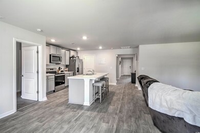 Kitchen with visible vents, a kitchen island with sink, appliances with stainless steel finishes, a kitchen breakfast bar, and open floor plan
