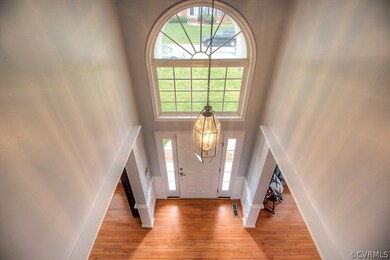 The two story foyer is welcoming with gleaming har