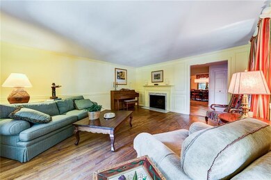 Formal living room has marble decorative fire plac