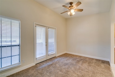 Carpeted empty room featuring a ceiling fan and ba