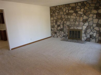 Living room off entry with real stone wall firepla