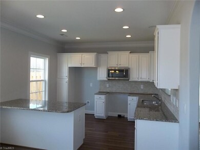 Gorgeous kitchen has hardwood flooring, granite countertops with subway tile backsplash, island cabinet with bar top, stainless steel appliance package (range is included), double crown molding and abundant recessed lighting.