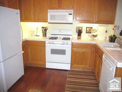 Open kitchen with ceramic tile counters.