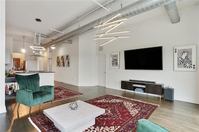 Living area with a high ceiling, wood finished floors, and baseboards