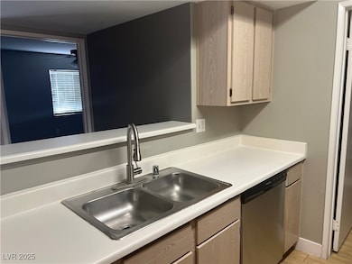 Kitchen with dishwasher, light brown cabinetry, an