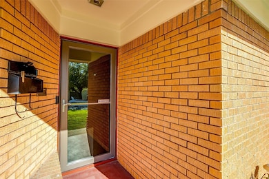 Property entrance featuring brick siding