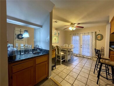 Kitchen with dark stone counters, sink, hanging li