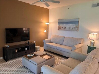 Tiled living room featuring ceiling fan