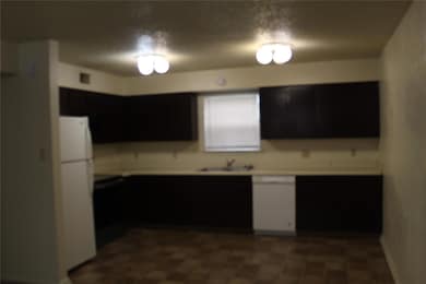 Kitchen featuring light countertops, a sink, dark 