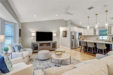 Living area featuring a ceiling fan, recessed lighting, light tile patterned floors, and vaulted ceiling