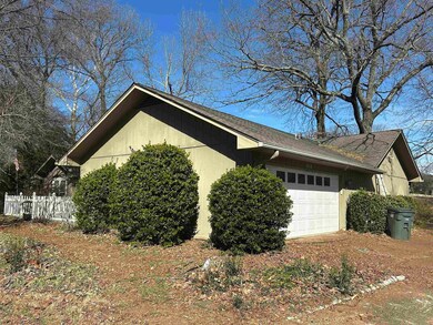 View of side of home featuring a garage and fence