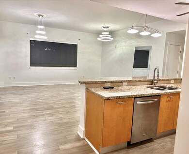 Kitchen with brown cabinetry, light stone counter