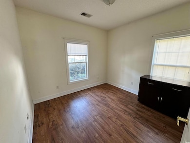 Unfurnished room with dark hardwood / wood-style f
