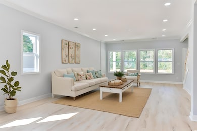 Living room featuring light wood-type flooring and crown molding