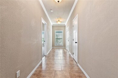 Corridor featuring visible vents, a textured wall,