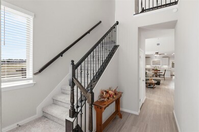Staircase featuring wood finished floors, a towering ceiling, and ceiling fan