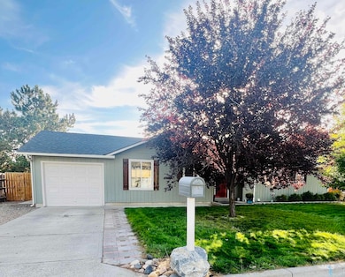 View of front of property featuring concrete driveway, a garage, and roof with shingles