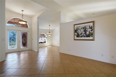 Foyer featuring a chandelier, french doors, and ti