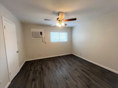 Spare room featuring a ceiling fan, dark wood-sty