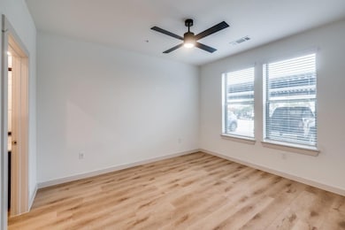 Empty room featuring visible vents, baseboards, an
