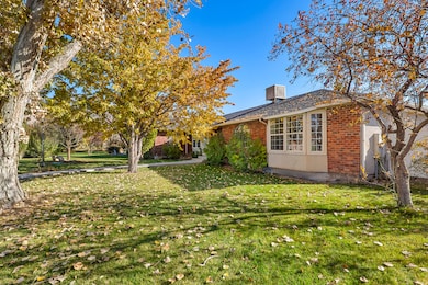 View of side of home featuring brick siding and a yard