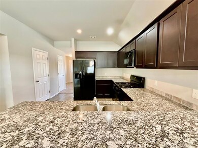 Kitchen with dark brown cabinets, light hardwood /