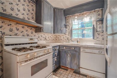 Small kitchen with faux painted cabinets.