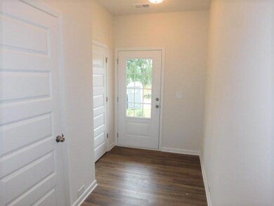 Doorway featuring dark wood-style flooring and baseboards