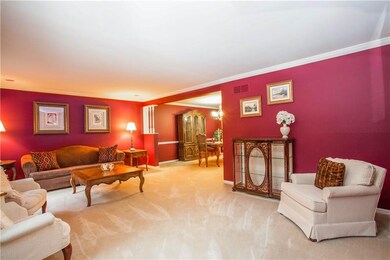 The Living Room Features Crown Molding & Plush Car