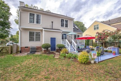 Rear view of house with deck and large patio area.