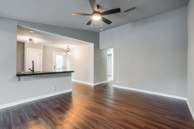 Spare room featuring dark wood-style flooring, lofted ceiling, a chandelier, and a ceiling fan
