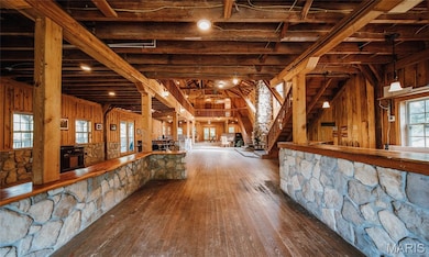 Bar featuring stairway, hardwood / wood-style flooring, wood walls, and beamed ceiling
