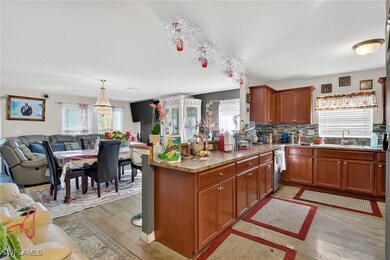 Kitchen featuring a peninsula, brown cabinetry, decorative backsplash, light wood-style flooring, and open floor plan